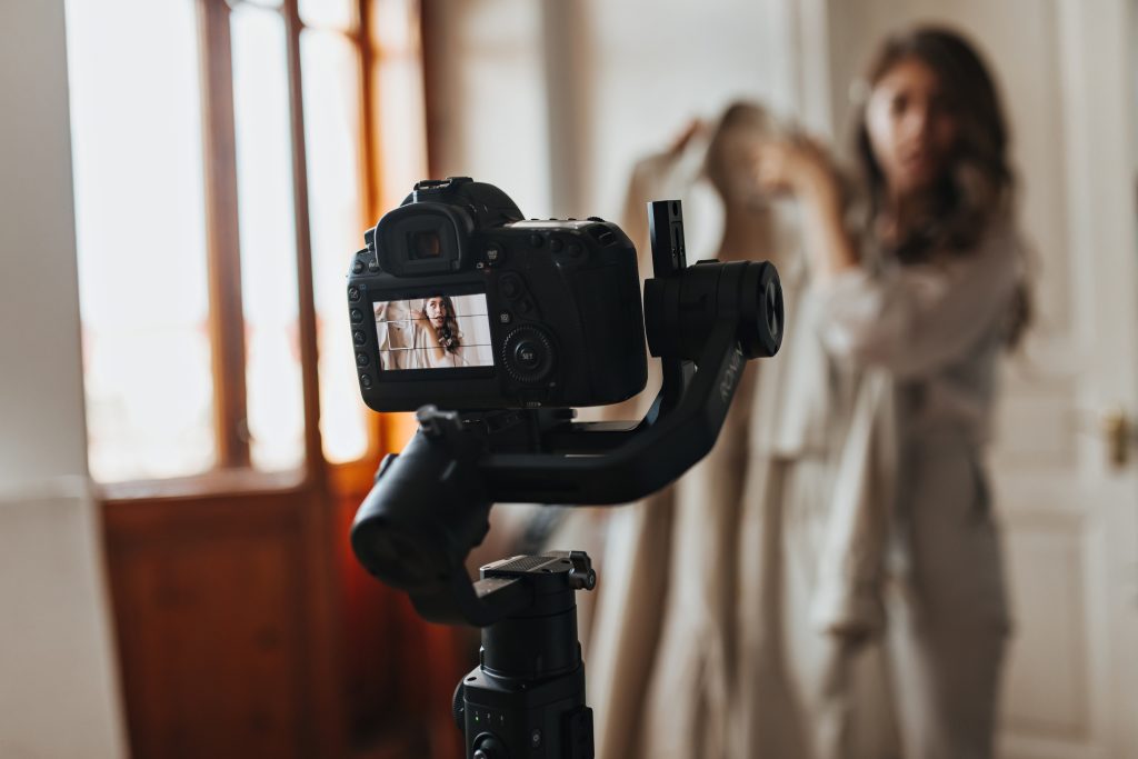lady in beige outfit posing for movie. snapshot of camera taking portrait photo of brunette woman h